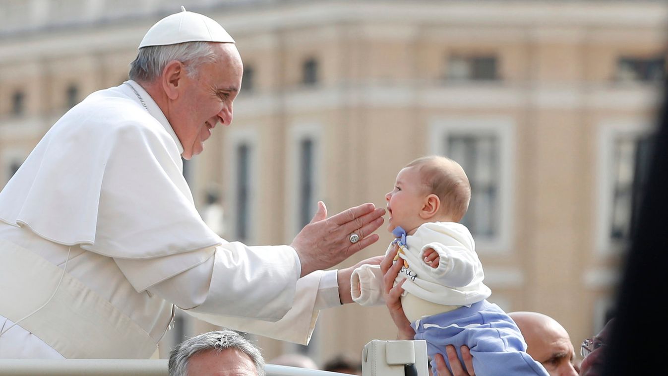 Pope Francis blesses a baby as he arrives to lead the weekly general audience in Saint Peter's Square at the Vatican