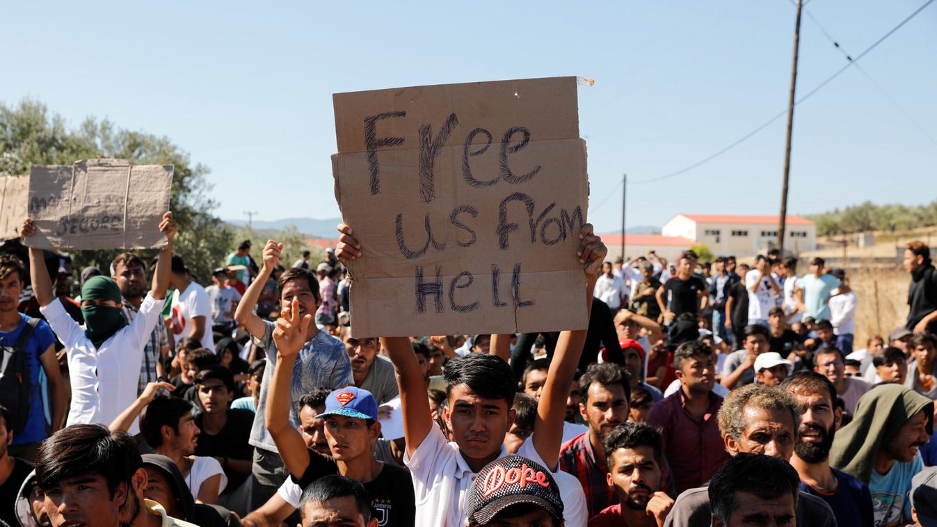 A migrant holds a placard as refugees and migrants take part in a demonstration against living conditions at the Moria camp on the island of Lesbos