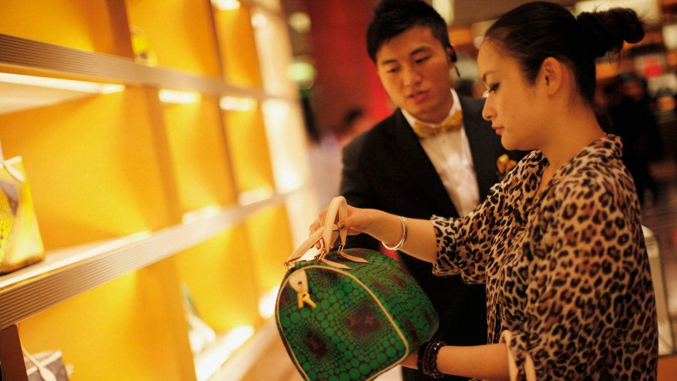 A woman shops in a Louis Vuitton store during Vogue's 4th Fashion's Night Out: Shopping Night with Celebrities in downtown Shanghai