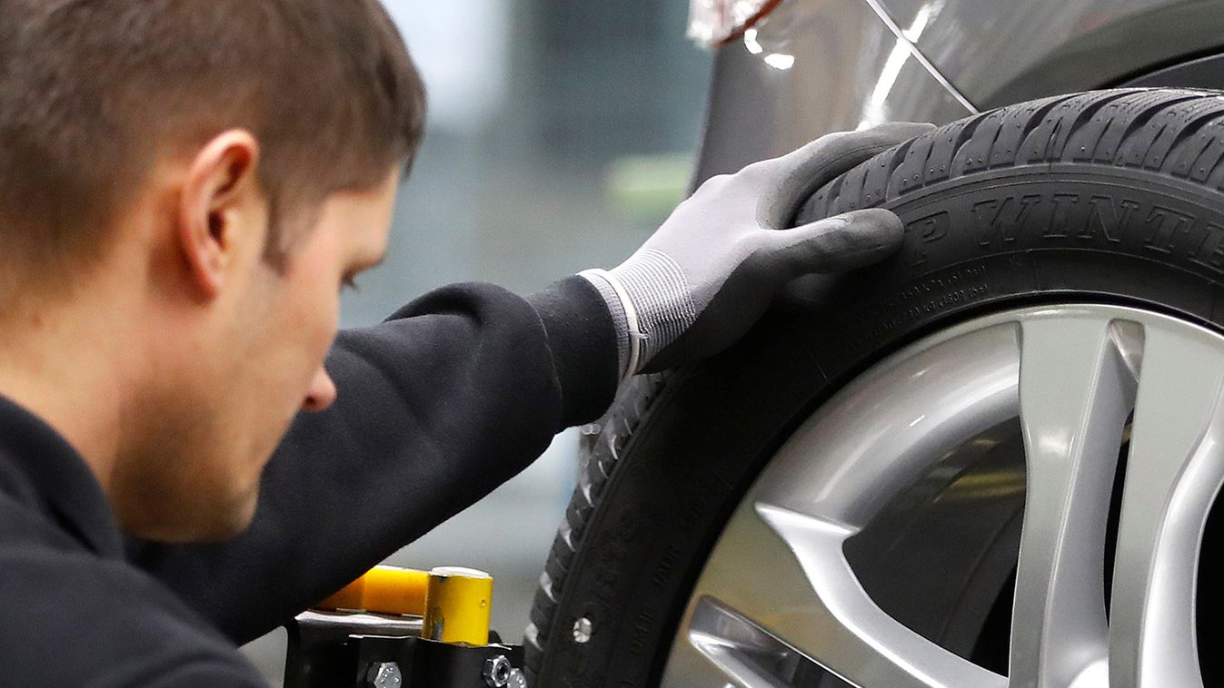 An employee of German car manufacturer Mercedes Benz installs wheel at a A-class model at the production line at the Daimler factory in Rastatt