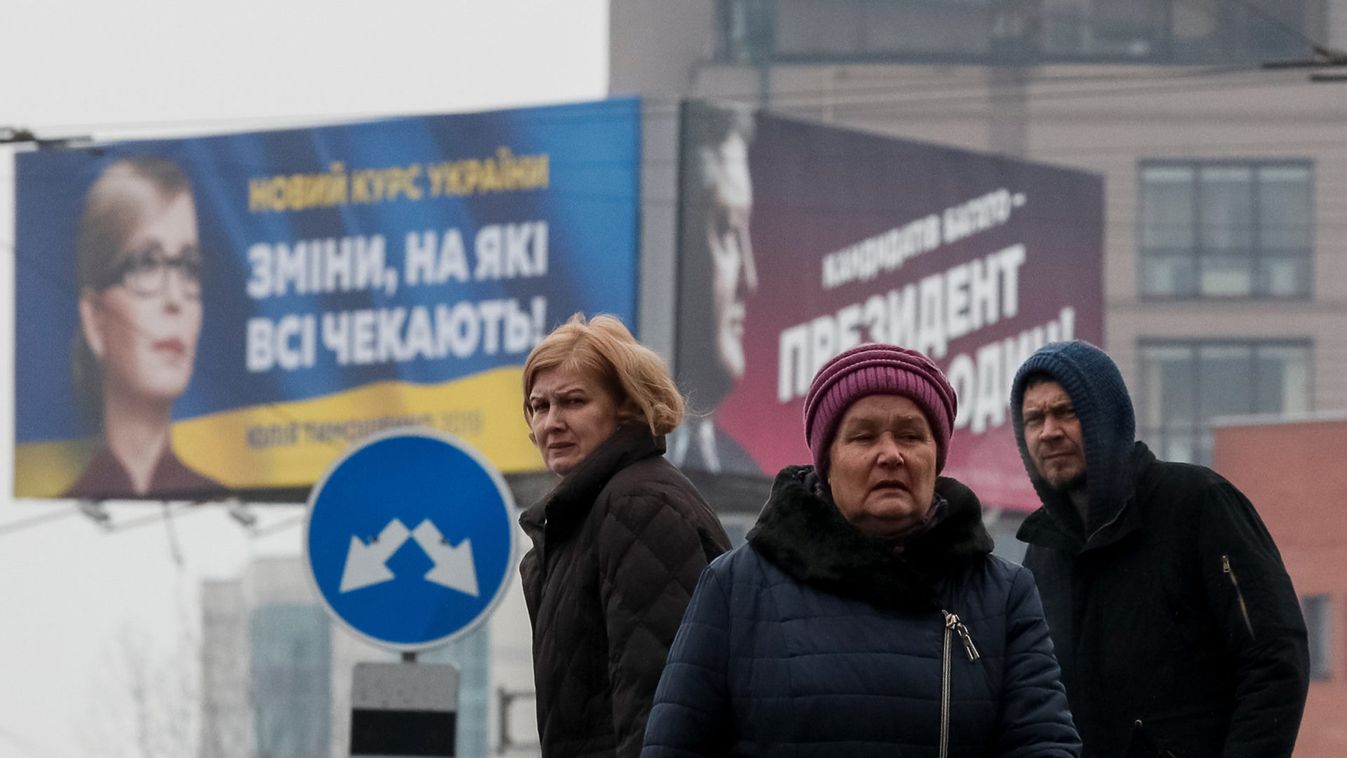People are seen in front of pre-election posters of opposition politician Yulia Tymoshenko and Ukrainian President Petro Poroshenko in Kiev