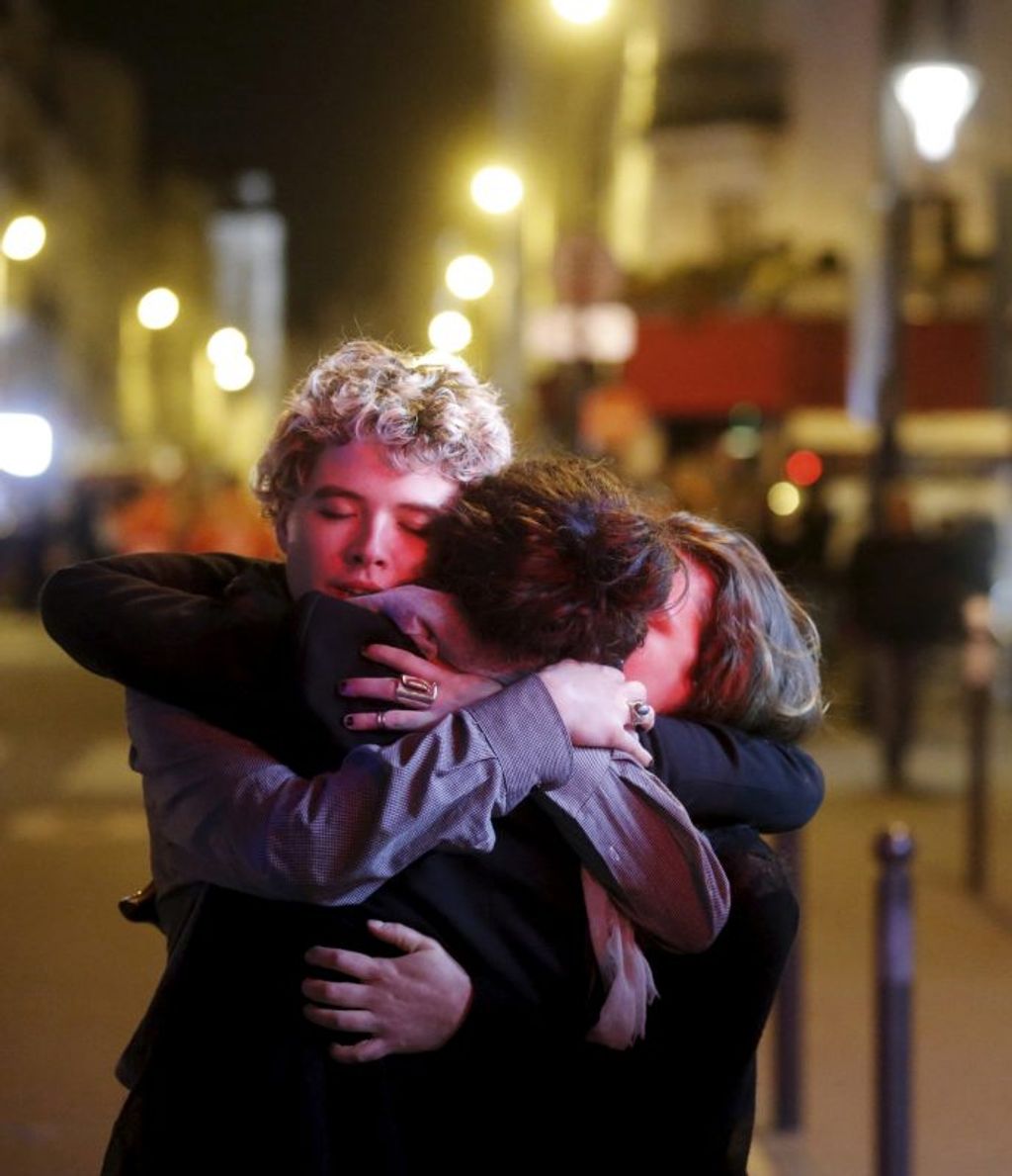 People hug on the street near the Bataclan concert hall following fatal attacks in Paris, France