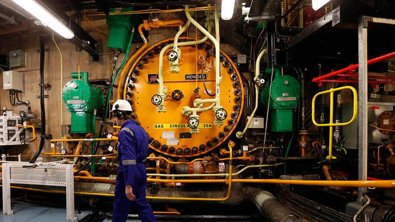 A worker walks past a gas circulator in the turbine hall inside EDF Energy's Hinkley Point B Nuclear Power Station in Bridgwater, southwest England