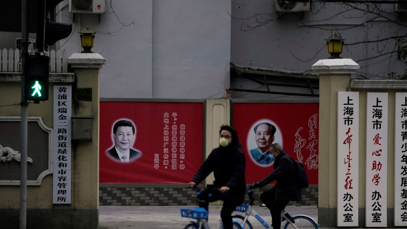 People wearing masks pass by portraits of Chinese President Xi Jinping and late Chinese chairman Mao Zedong as the country is hit by an outbreak of the novel coronavirus, on a street in Shanghai