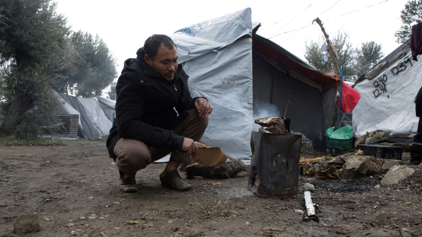 A Migrant lights up a fire at a makeshift camp next to the Moria camp for refugees and migrants on the island of Lesbos