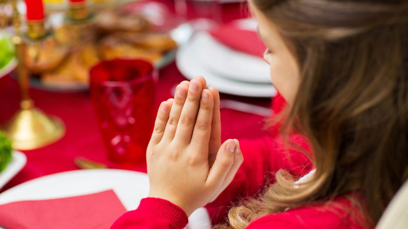 close up of girl praying at christmas dinner