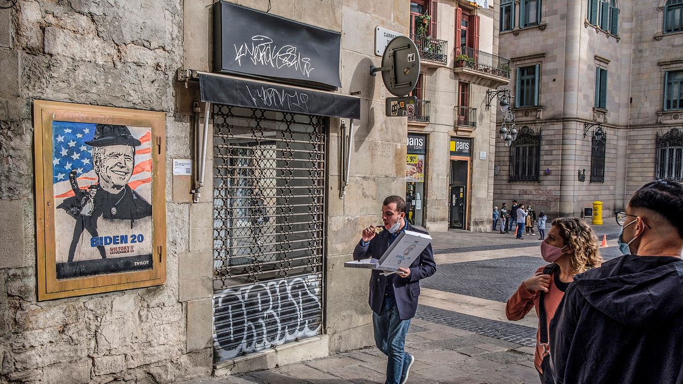 A man eating pizza walking past the new graffiti. Street