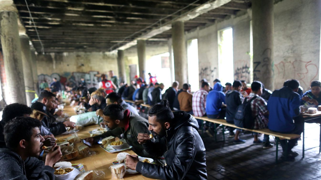 Migrants eat in a dorm destroyed during the Bosnian 1992-1995 war, in Bihac