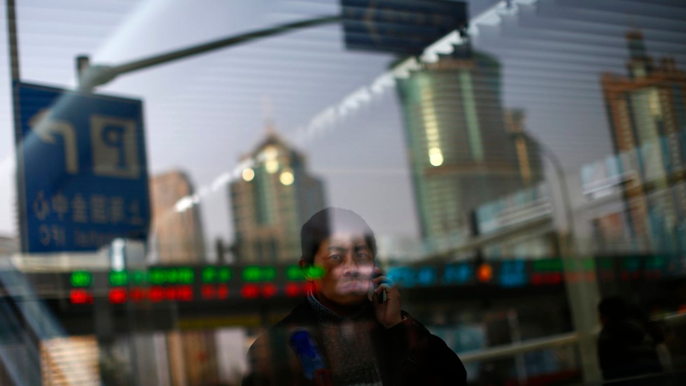 A man walks out of a subway station as he talk on the phone at the financial district of Pudong in Shanghai