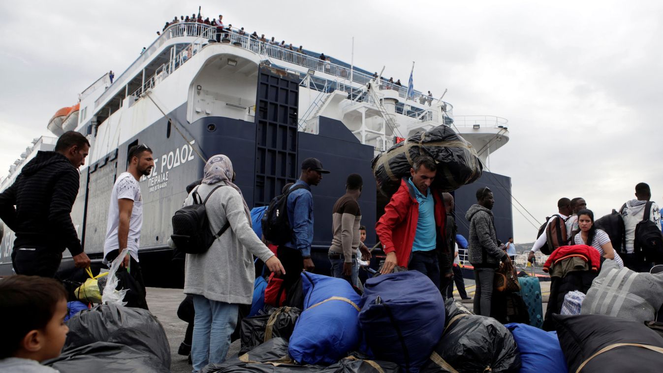 Migrants wait to board the Nissos Rodos passenger ship at the port of Mytilene on the island of Lesbos