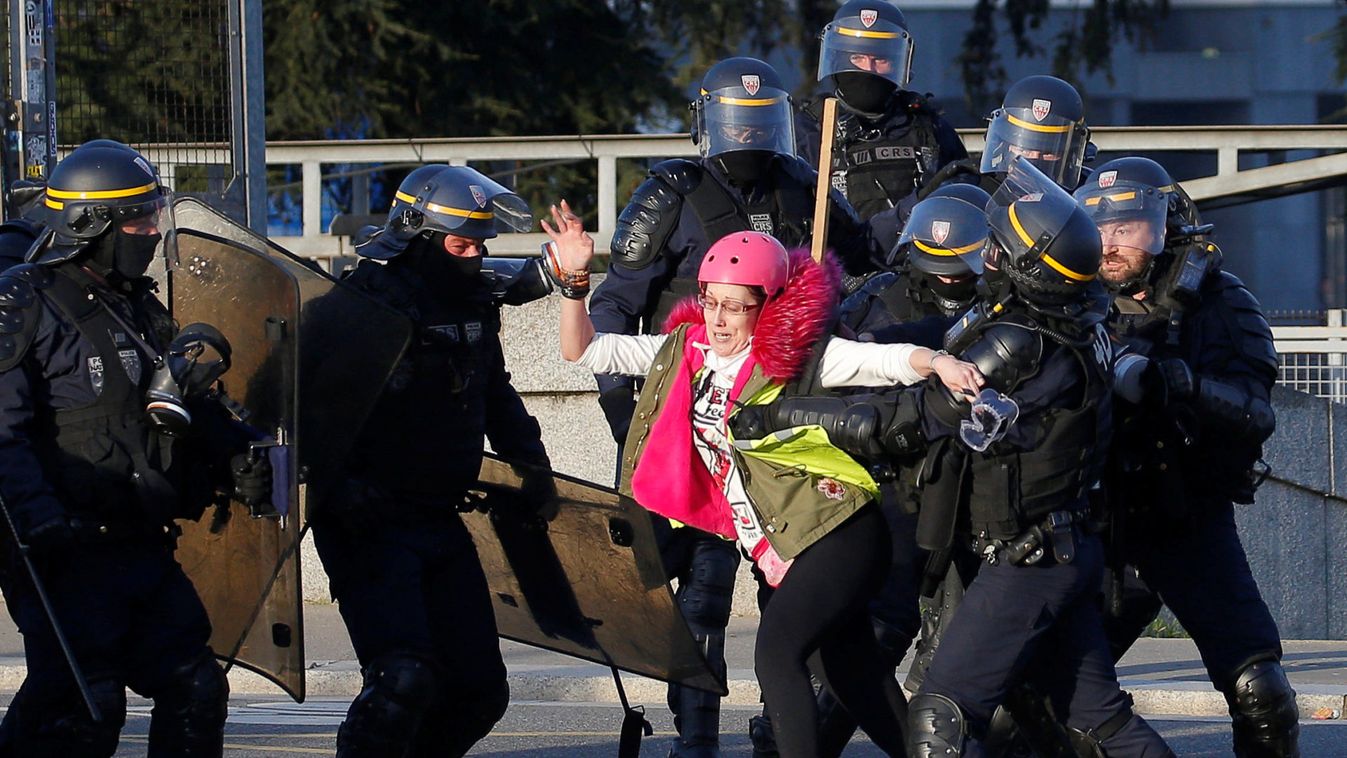 A protester is pushed back by police during a demonstration of the "yellow vests" movement in Nantes