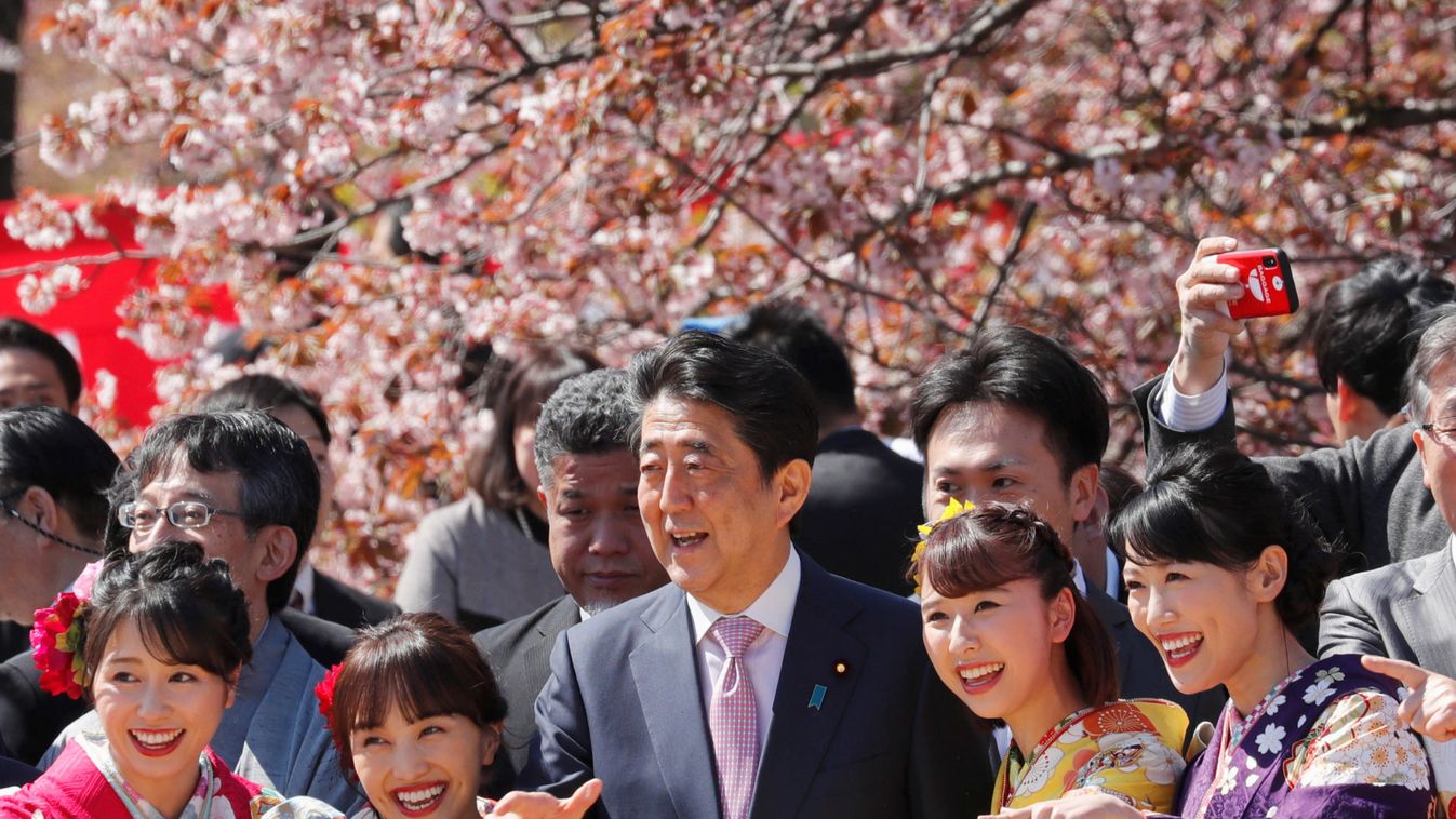 Japan's Prime Minister Shinzo Abe poses with guests during a cherry blossom viewing party at Shinjuku Gyoen park in Tokyo