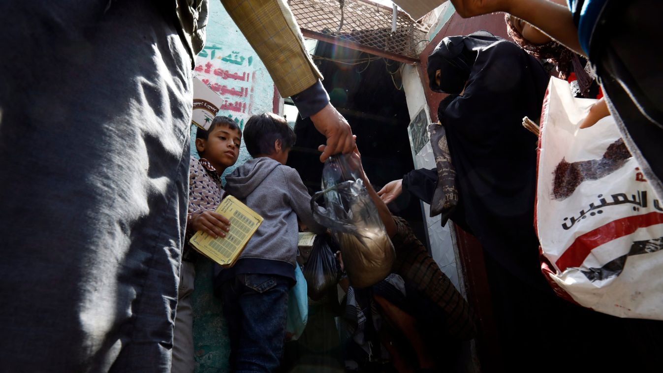 Yemenis get free food ration from a charity group