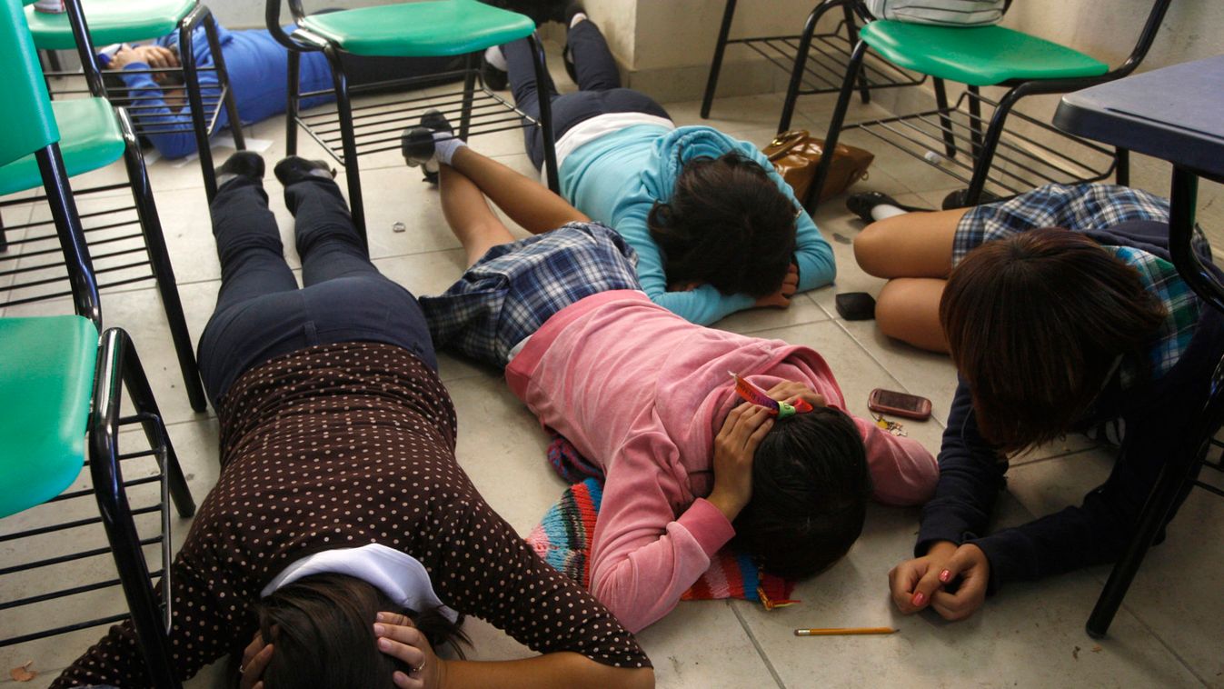 Students lie face down in a classroom during a mock drill in a local high school in a low-income neighbourhood in Ciudad Juarez