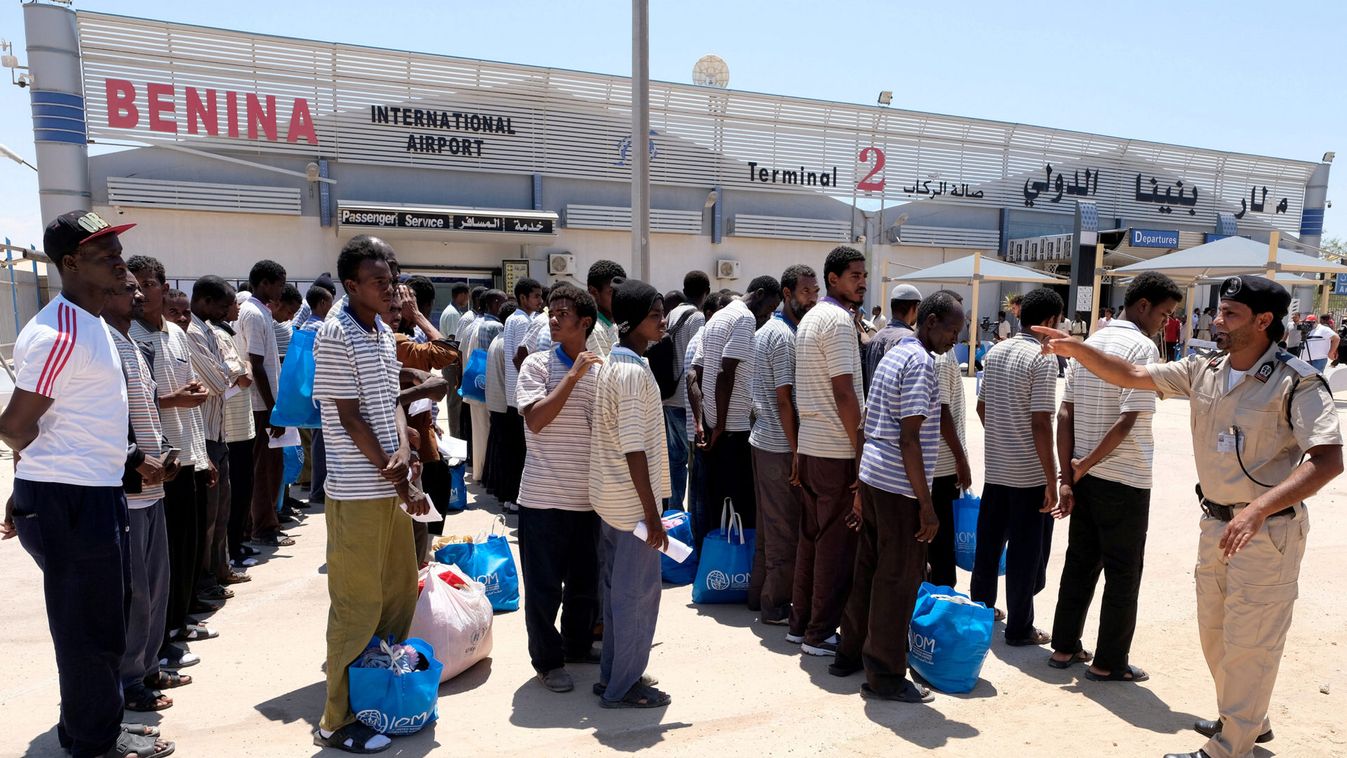 Illegal Sudanese migrants stand in a queue, as they wait to be deported to their country at Benina International Airport in Benghazi