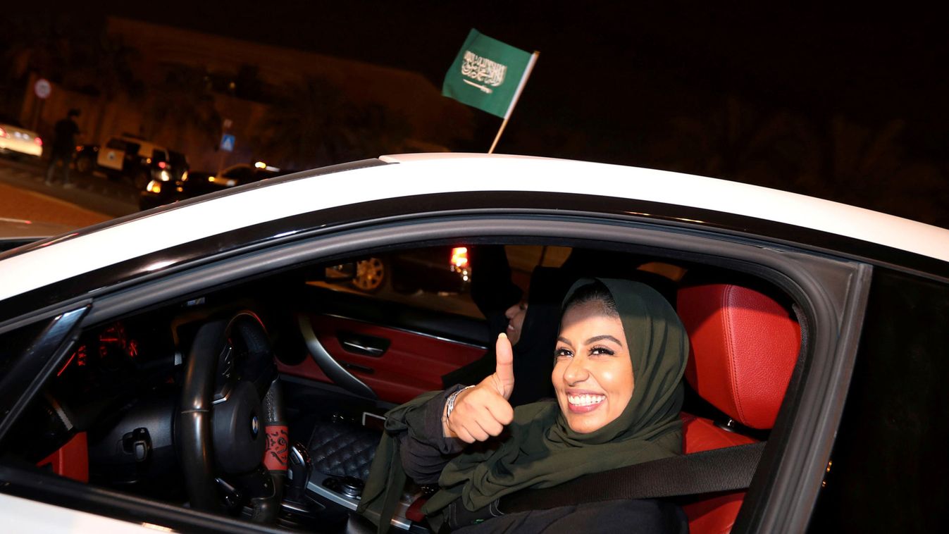 A Saudi woman celebrates as she drives her car in her neighborhood, in Al Khobar