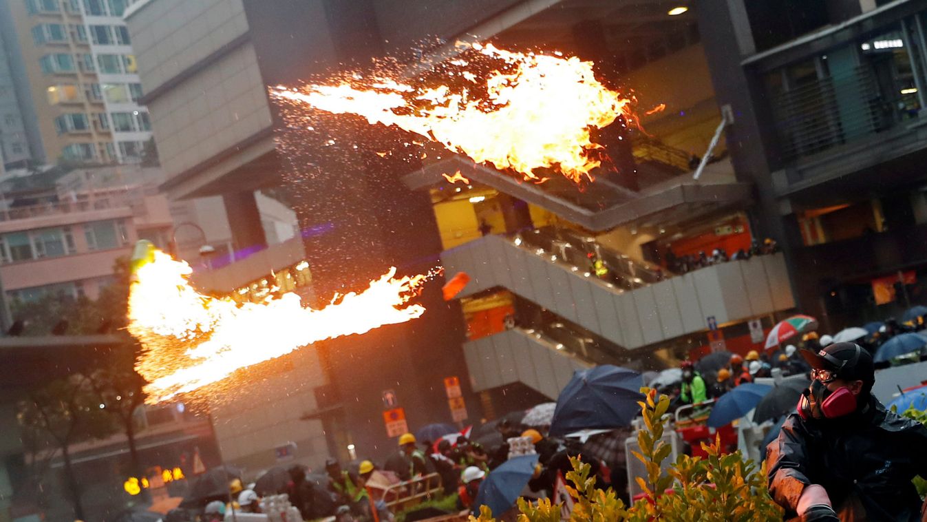 An anti-extradition bill protester throws a Molotov cocktail as protesters clash with riot police during a rally to demand democracy and political reforms, at Tsuen Wan, in Hong Kong