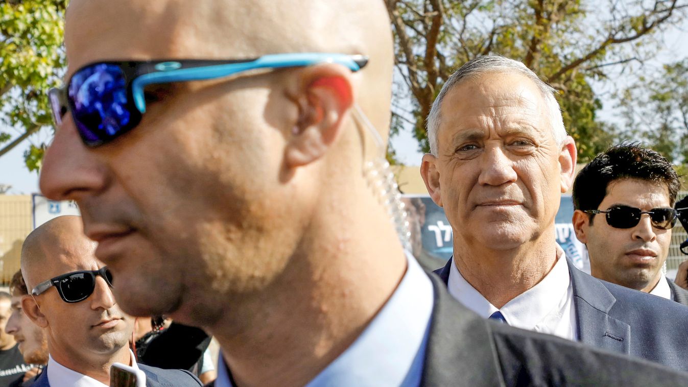 Benny Gantz, leader of Blue and White party, is surrounded by bodyguards and members of the media after casting his ballot as Israelis began voting in a parliamentary election, near a polling station in Rosh Ha'ayin, Israel
