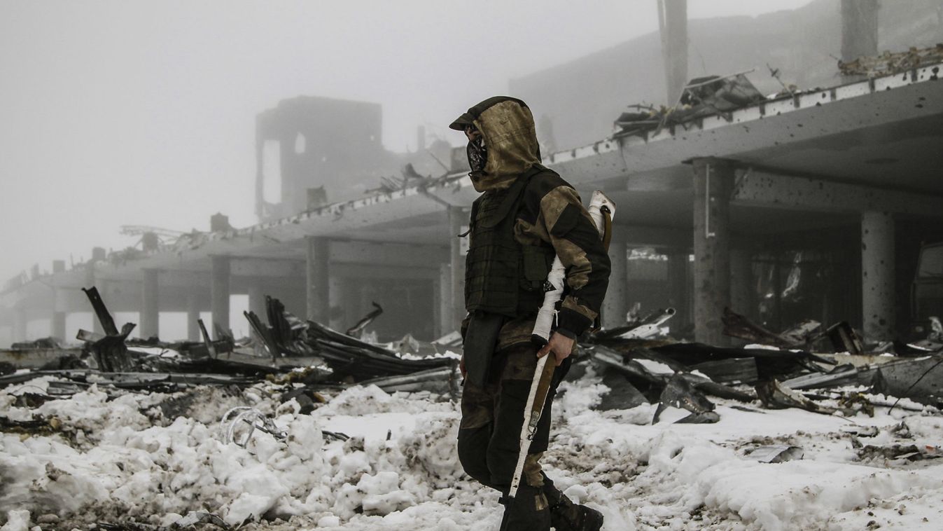 Member of self-proclaimed Donetsk People's Republic forces walks near building destroyed during battles with Ukrainian armed forces at Donetsk airport
