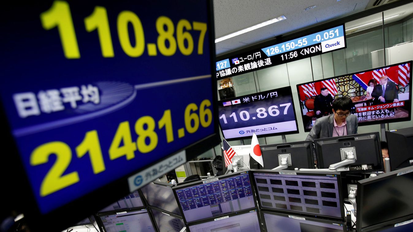 Employees of a foreign exchange trading company work next to monitors displaying Japan's Nikkei stock average and the Japanese yen's exchange rate against the U.S. dollar as a television screen broadcasting second North Korea-U.S. summit in Tokyo