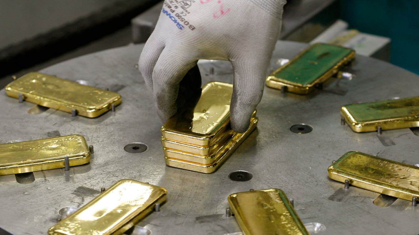 An employee places bars of one kilogram fine gold on a machine before marking with a stamp at a plant of gold refiner and bar manufacturer Argor-Heraeus SA in the southern Swiss town of Mendrisio