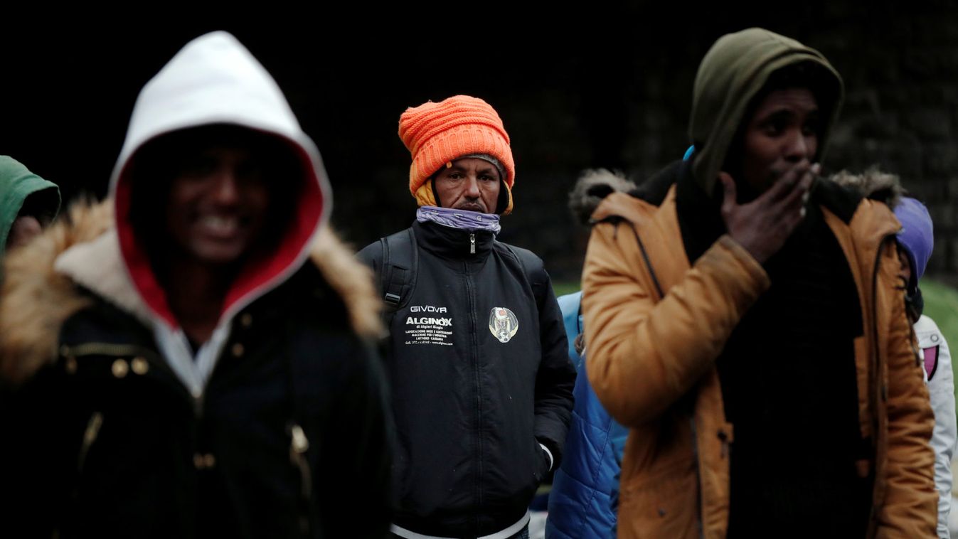 Migrants stand in line as French police evacuate hundreds of migrants living in makeshift camp set up under the Porte de la Chapelle ring bridge in Paris