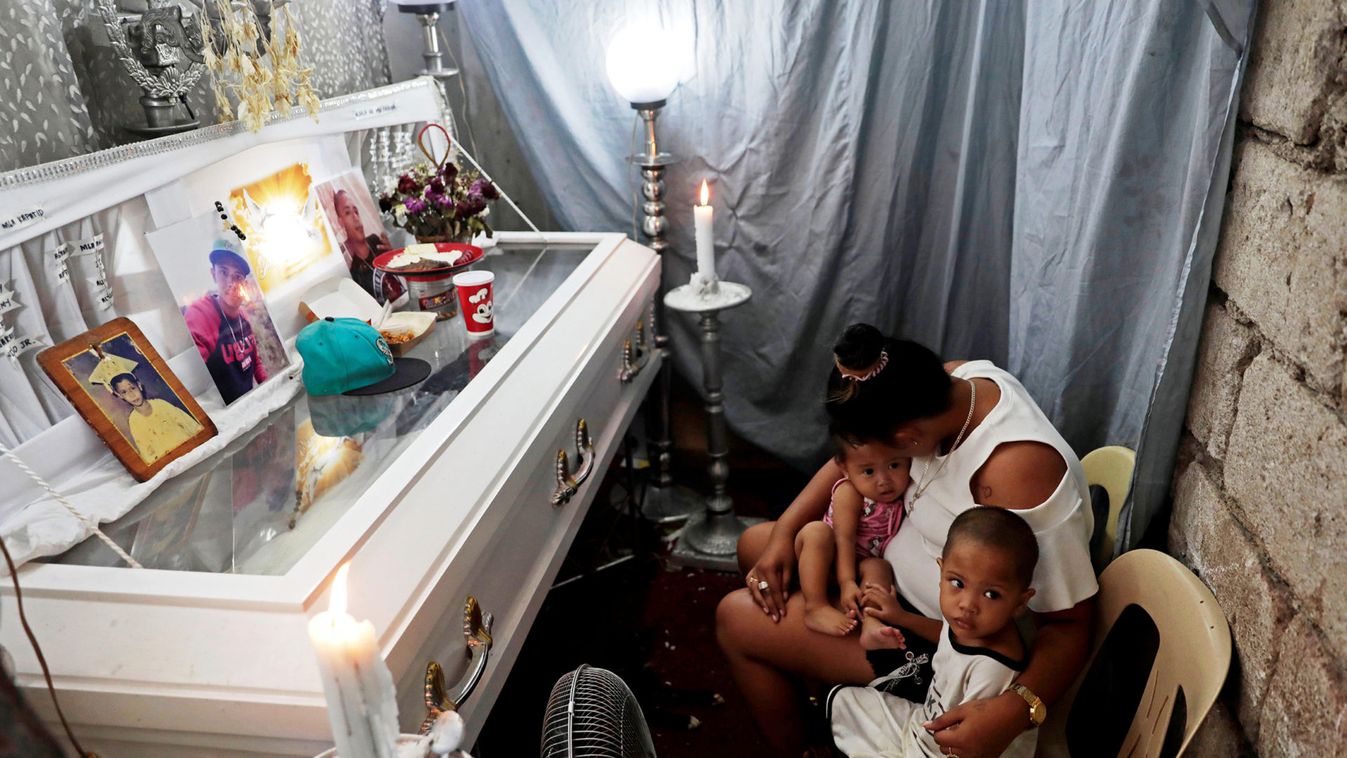 The wife and kids of 23-year-old Jaybee Castor sit beside his casket a few hours before his funeral in his home in Caloocan City