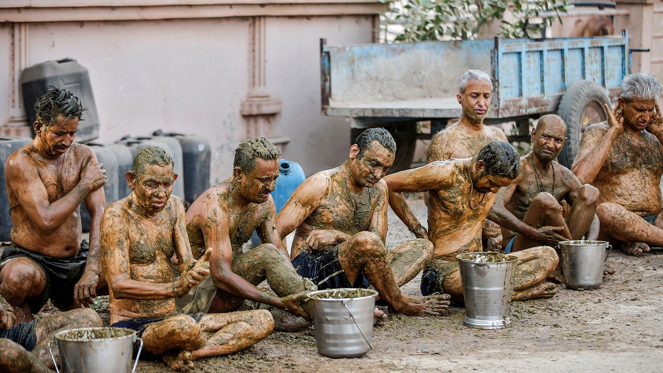 People apply cow dung on their bodies during "cow dung therapy" on outskirts of Ahmedabad