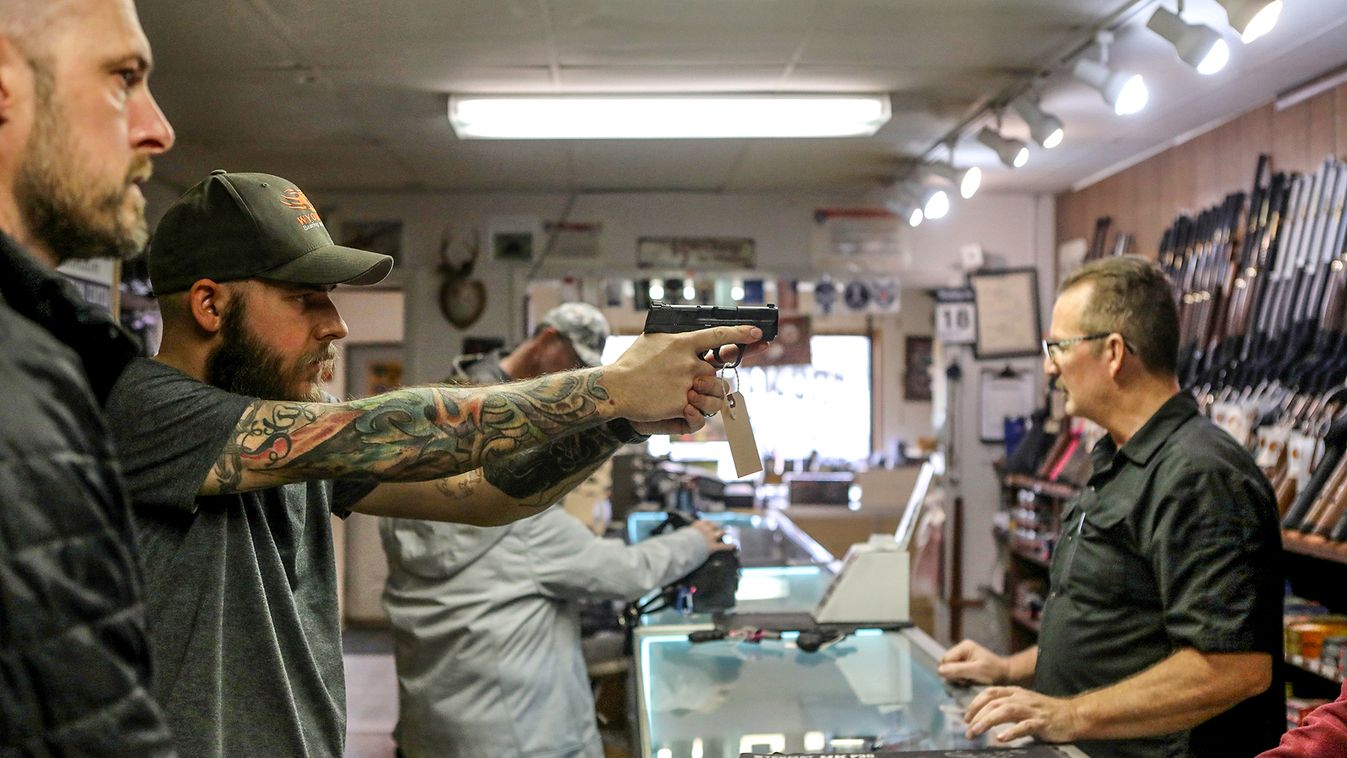 A man holds a semi-automatic handgun at Frontier Arms & Supply gun shop amid fears of the global growth of coronavirus disease (COVID-19) cases, in Cheyenne