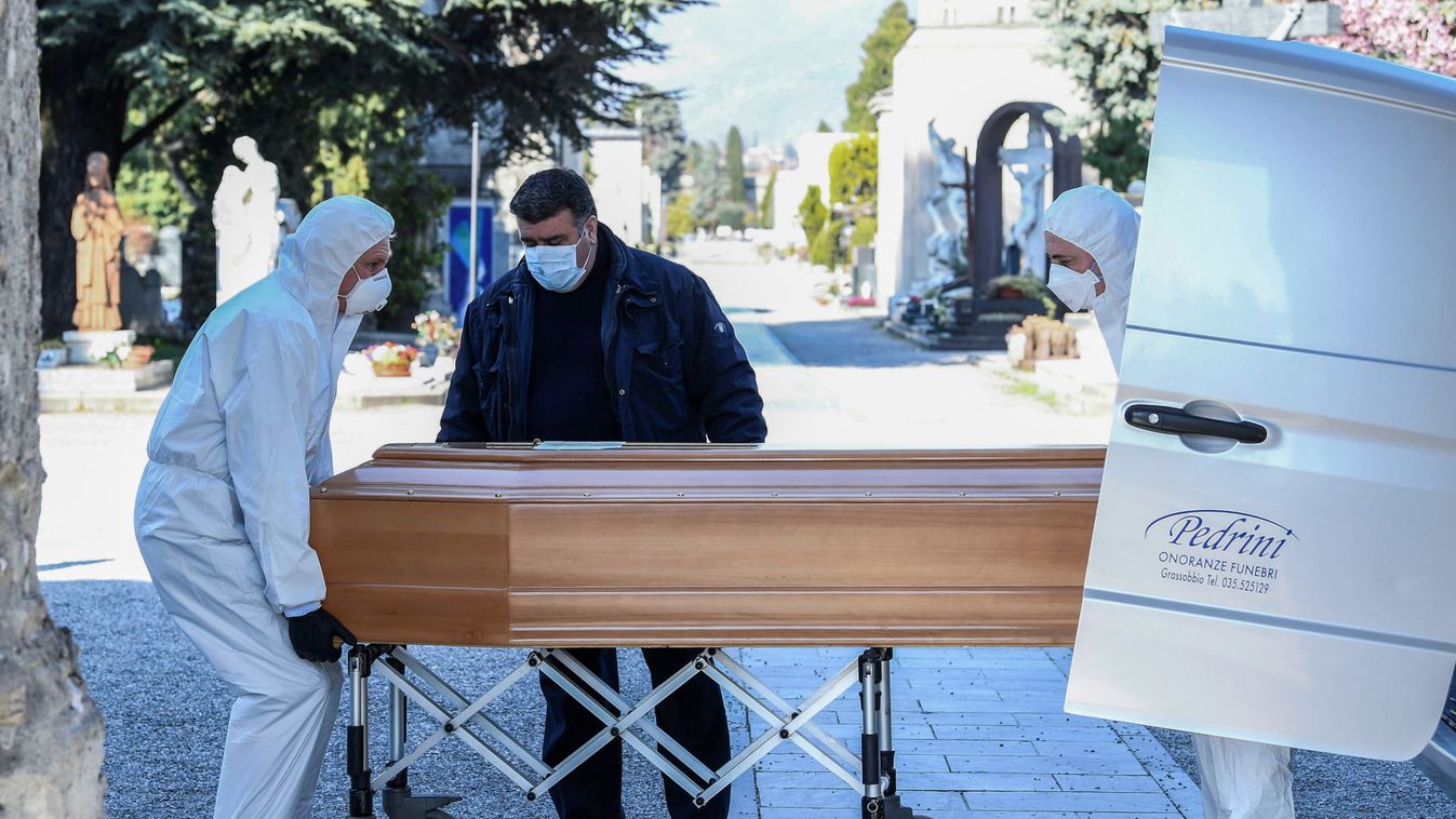 Men in protective masks transport a coffin of a person who died from coronavirus disease (COVID-19), into a cemetery in Bergamo