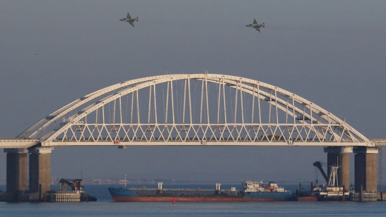 Russian jet fighters fly over a bridge connecting the Russian mainland with the Crimean Peninsula with a cargo ship beneath it after three Ukrainian navy vessels were stopped by Russia from entering the Sea of Azov via the Kerch Strait in the Black Sea