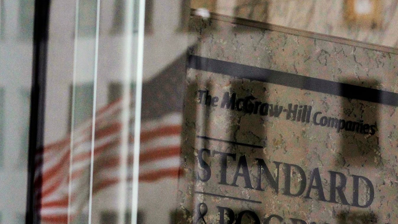 A U.S. flag is reflected in a window of the Standard and Poor's building in New York