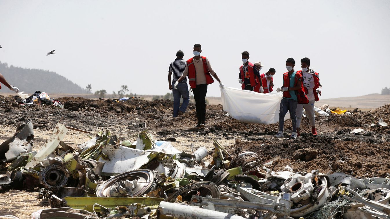 Ethiopian Red Cross workers carry a body bag with the remains of Ethiopian Airlines Flight ET 302 plane crash victims at the scene of a plane crash, near the town of Bishoftu, southeast of Addis Ababa