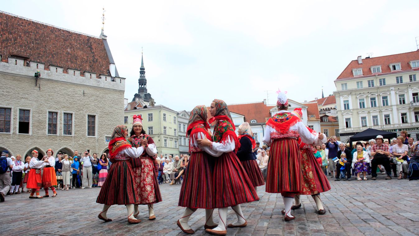 People wear traditional dress of Kihnu island as they dance during traditional culture day in Tallinn