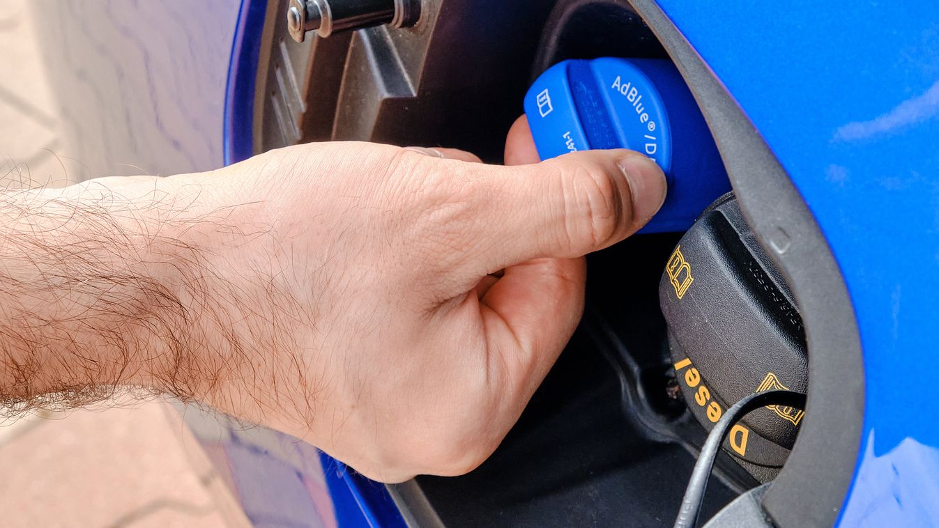 Close up mans hand opening a tank for Ad Blue fluid of a blue car. Diesel exhaust fluid or DEF for reduction of air pollution, October 2020, Prague, Czech Republic