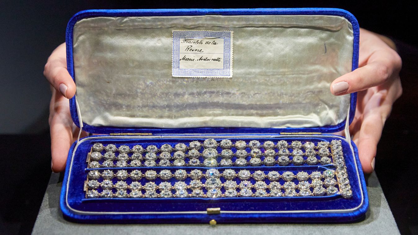 A staff holds a blue velvet case containing a pair of diamond bracelets before their auction sale in Geneva