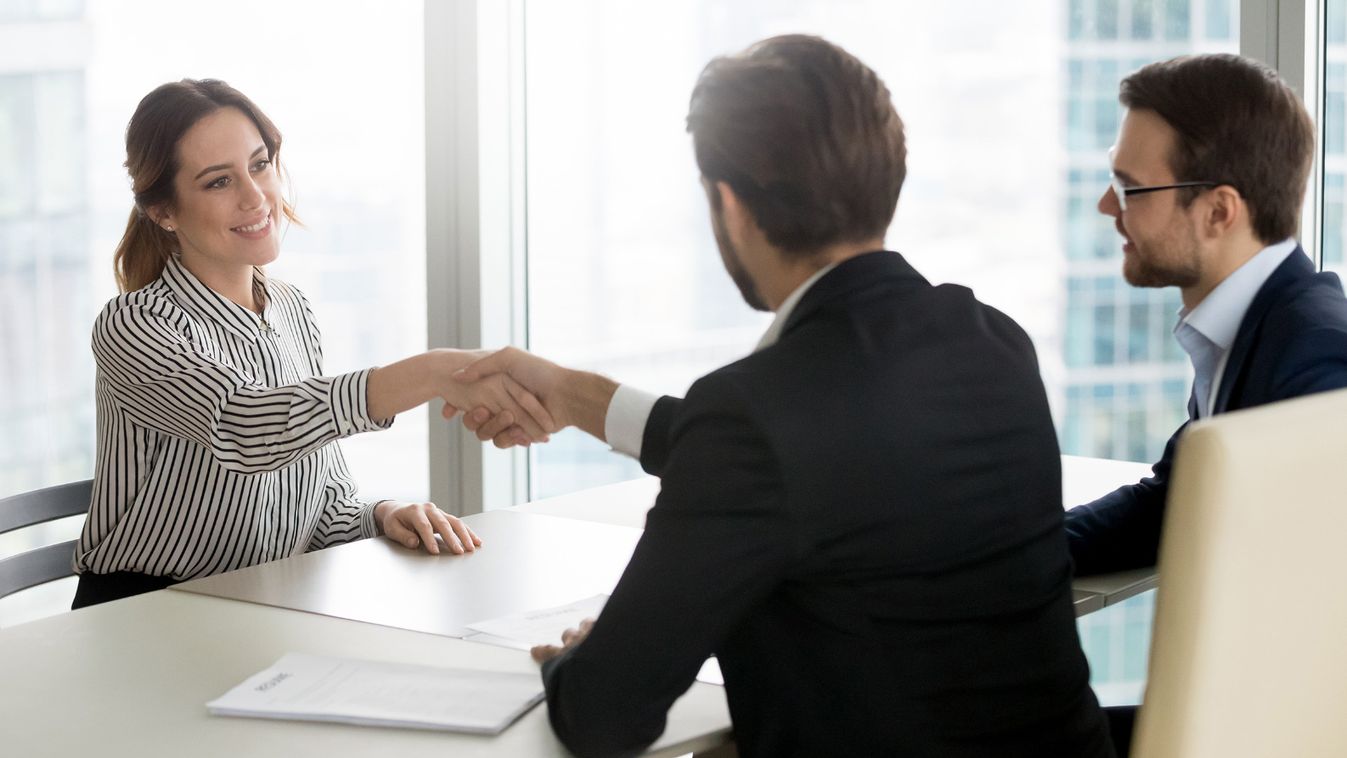 Confident female job applicant shaking hand of hr recruiting manager