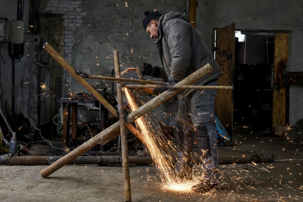 Ukrainian people assemble an anti-tank Czech hedgehog