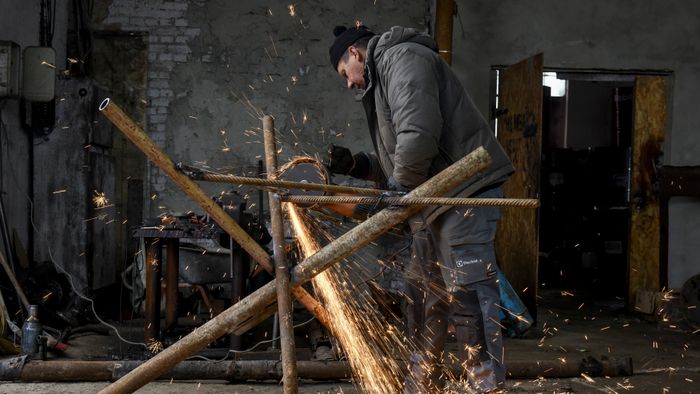 Ukrainian people assemble an anti-tank Czech hedgehog