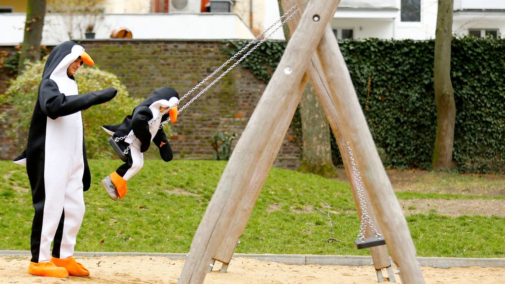 People dressed as penguins play at a playground on the "Rosenmontag" (Rose Monday) in Cologne