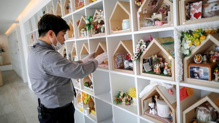 Kang Sung-il, a pet funeral manager, checks urns containing pet's ashes at a pet funeral service company in Gwangju