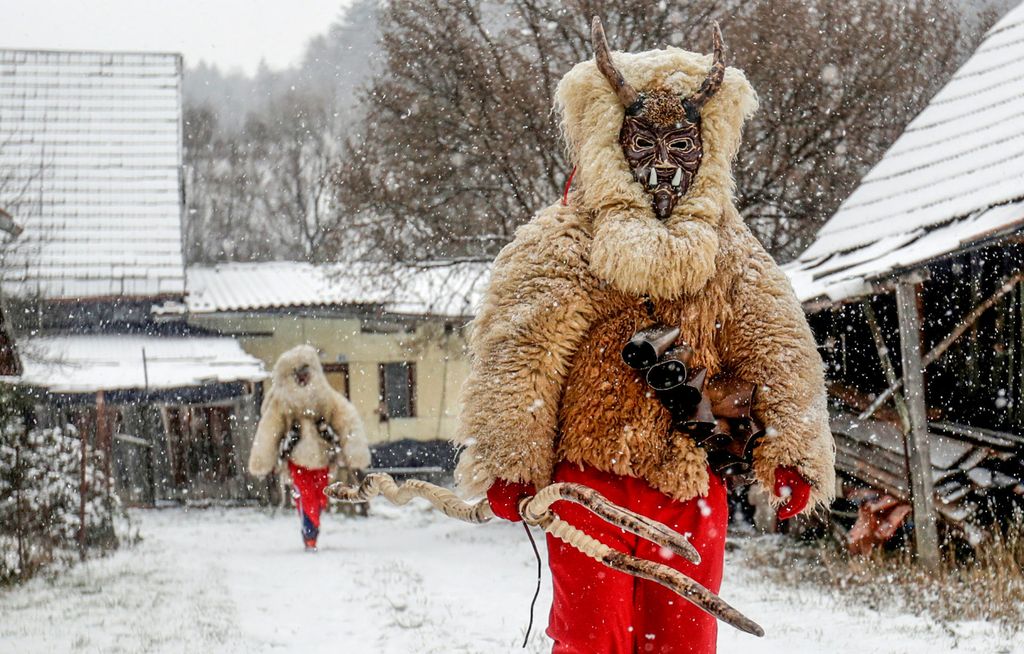 Revellers dressed as devils walk through the village of Valasska Polanka