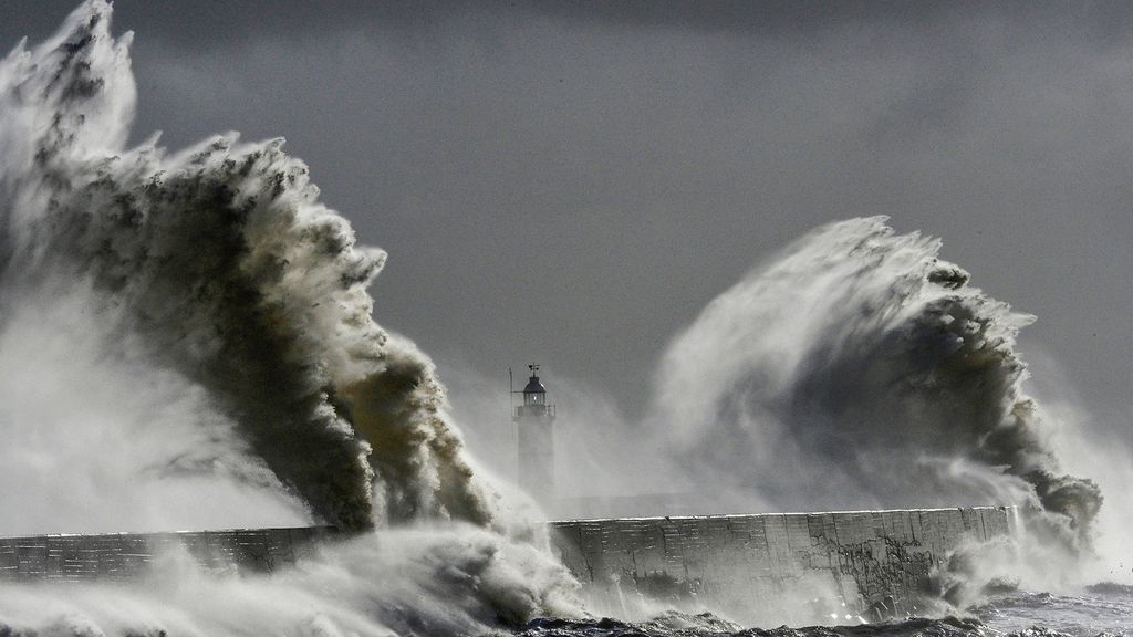 Large waves hit the lighthouse and harbour at high tide at Newhaven in Sussex, southern England