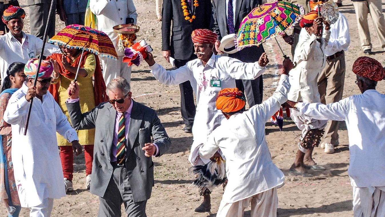 Britain's Prince Charles dances with villagers at Tolasar