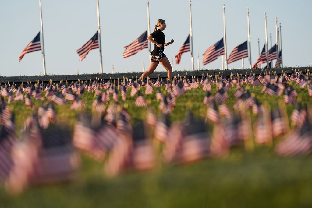 American flags representing 200,000 lives lost due to coronavirus are placed on National Mall in Washington