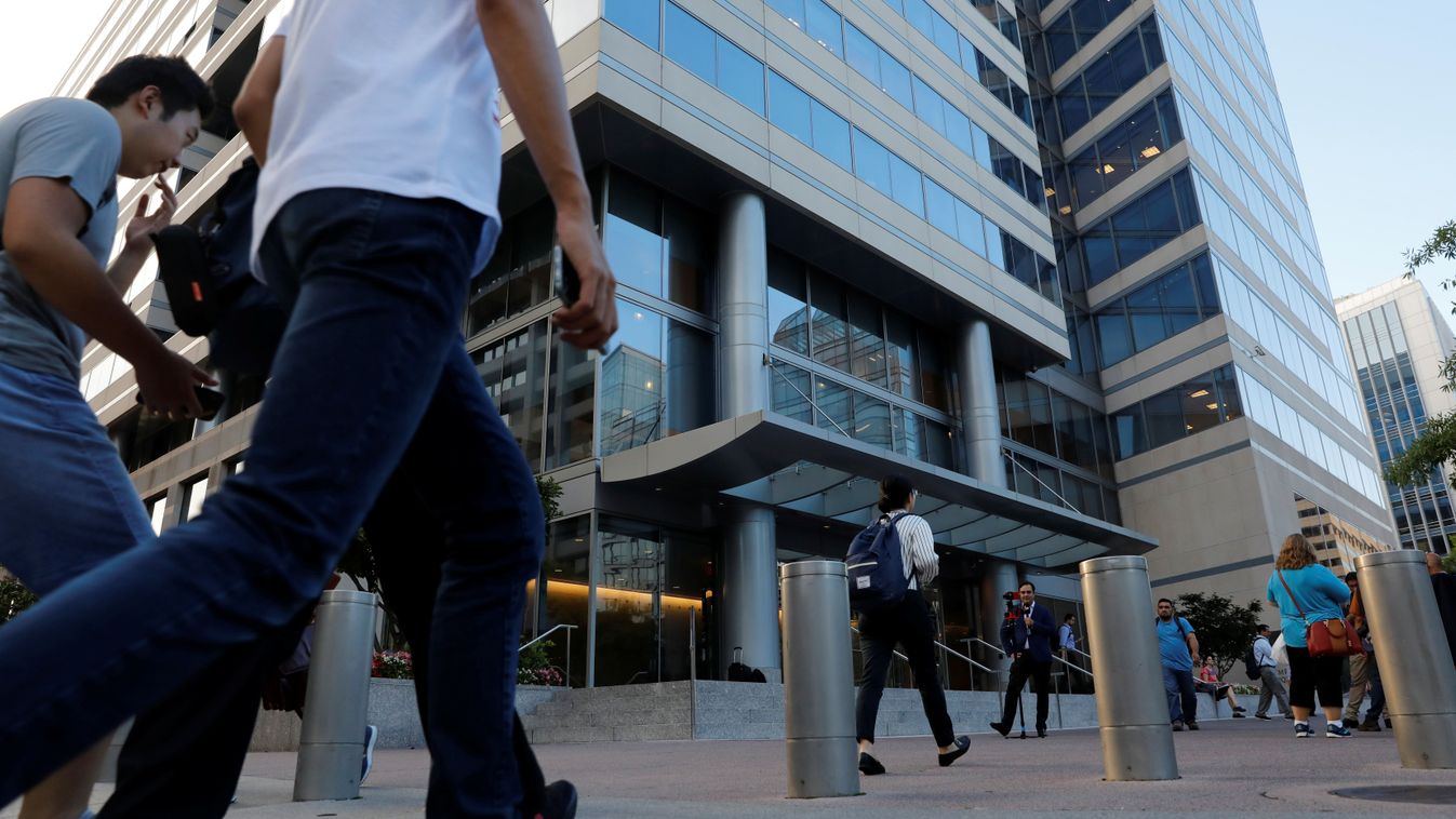 People walk past the IMF headquarters building in Washington