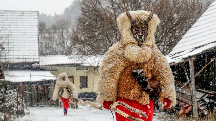 Revellers dressed as devils walk through the village of Valasska Polanka