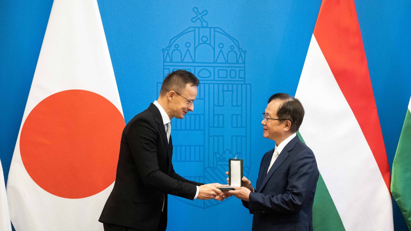 Szijjártó Péter külgazdasági- és külügyminiszter átadja a Magyar Érdemrend lovagkeresztjét Szato Josiónak, Japán Üzleti Szövetség európai vezetőjének.