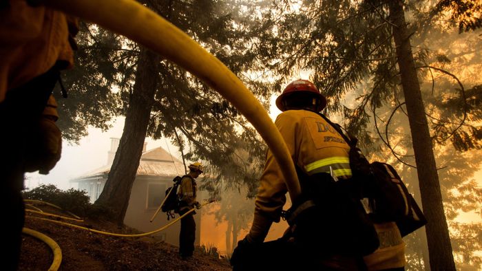 Firefighters battle a wildfire near a structure while defending the Mount Wilson observatory during the Bobcat Fire in Los Angeles