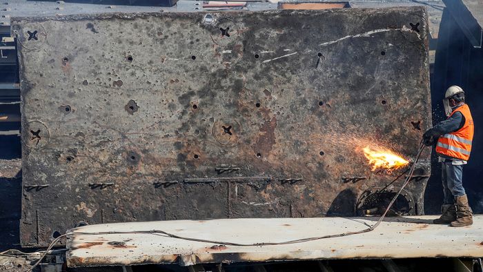 A labourer seperates parts of a decommissioned cruise ship  being dismantled at Aliaga ship-breaking yard in the Aegean port city of Izmir